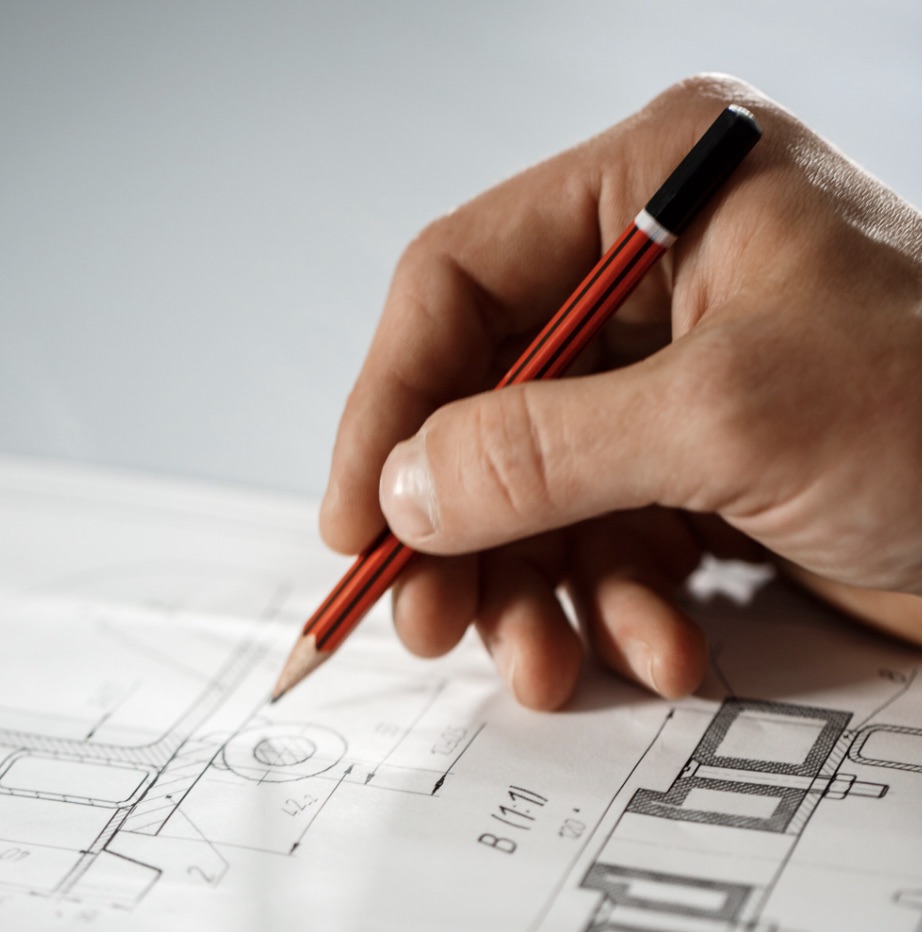 Mani che disegnano un progetto architettonico